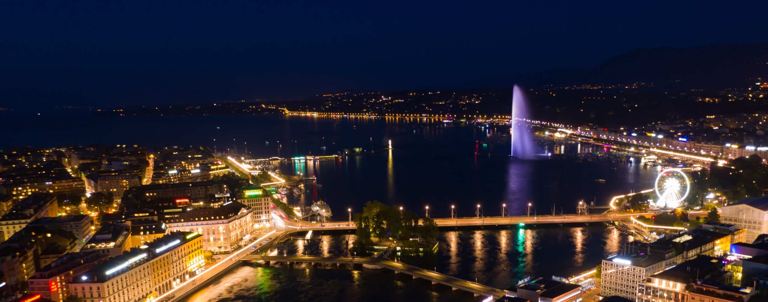 aerial-night-view-of-geneva-city-water-fountain-i-2025-01-08-04-41-07-utc